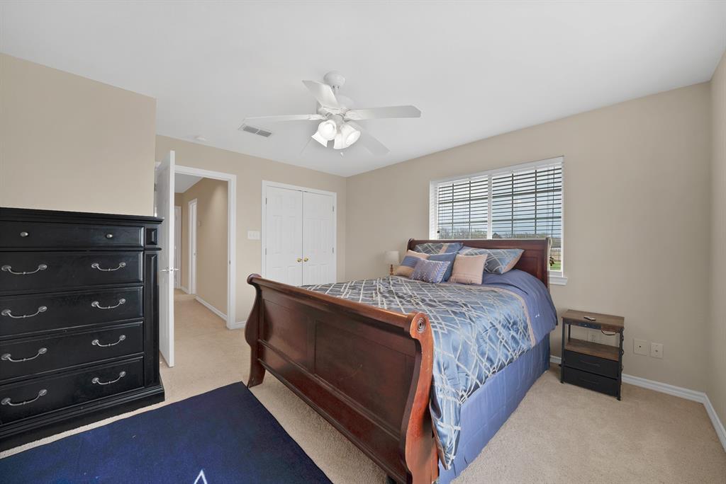 11692 Foutch Road Pilot Point, TX 76258 - Photo 25 of 40 a bedroom with a bed and a chandelier