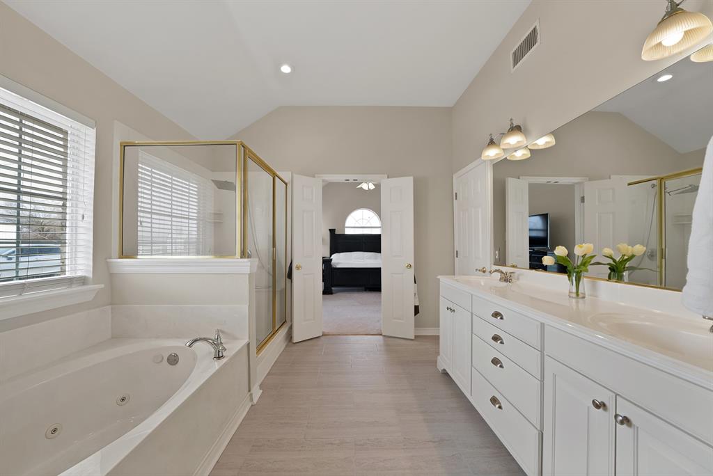 11692 Foutch Road Pilot Point, TX 76258 - Photo 28 of 40 a spacious en suite bathroom with a granite countertop double vanity sink a bathtub and a window