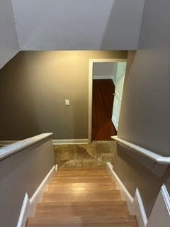 203 Indian Trail Road Seneca, SC 29672 - Photo 8 of 14 Polished wooden stairs lead down to a tiled landing and adjoining rooms.
