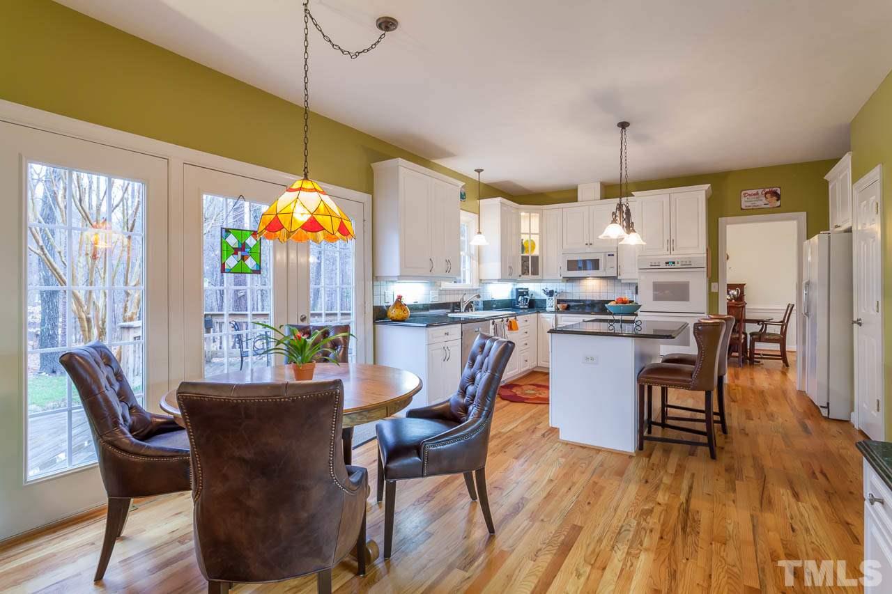 5404 Killarney Hope Drive Raleigh, NC 27613 - Photo 22 of 22 a dining room with stainless steel appliances a dining table chairs and a refrigerator