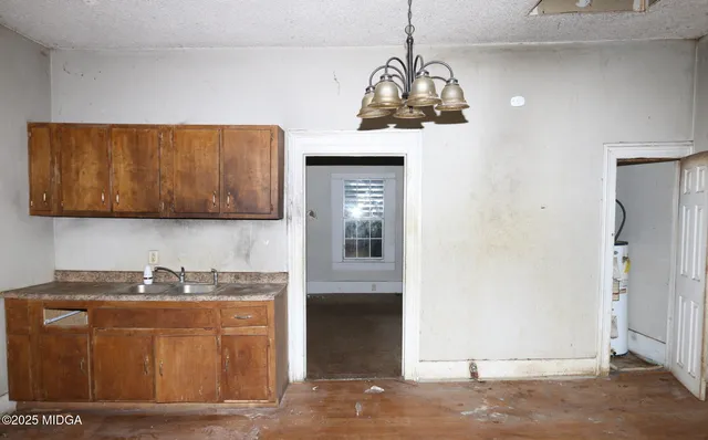 a view of a kitchen with stainless steel appliances granite countertop a refrigerator a oven and a sink with granite countertops