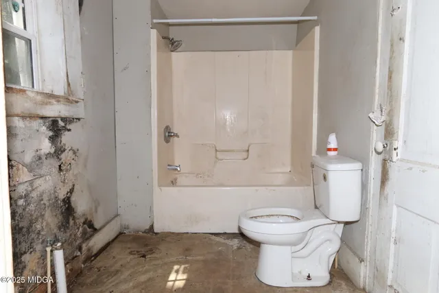 a bathroom with a toilet and a shower