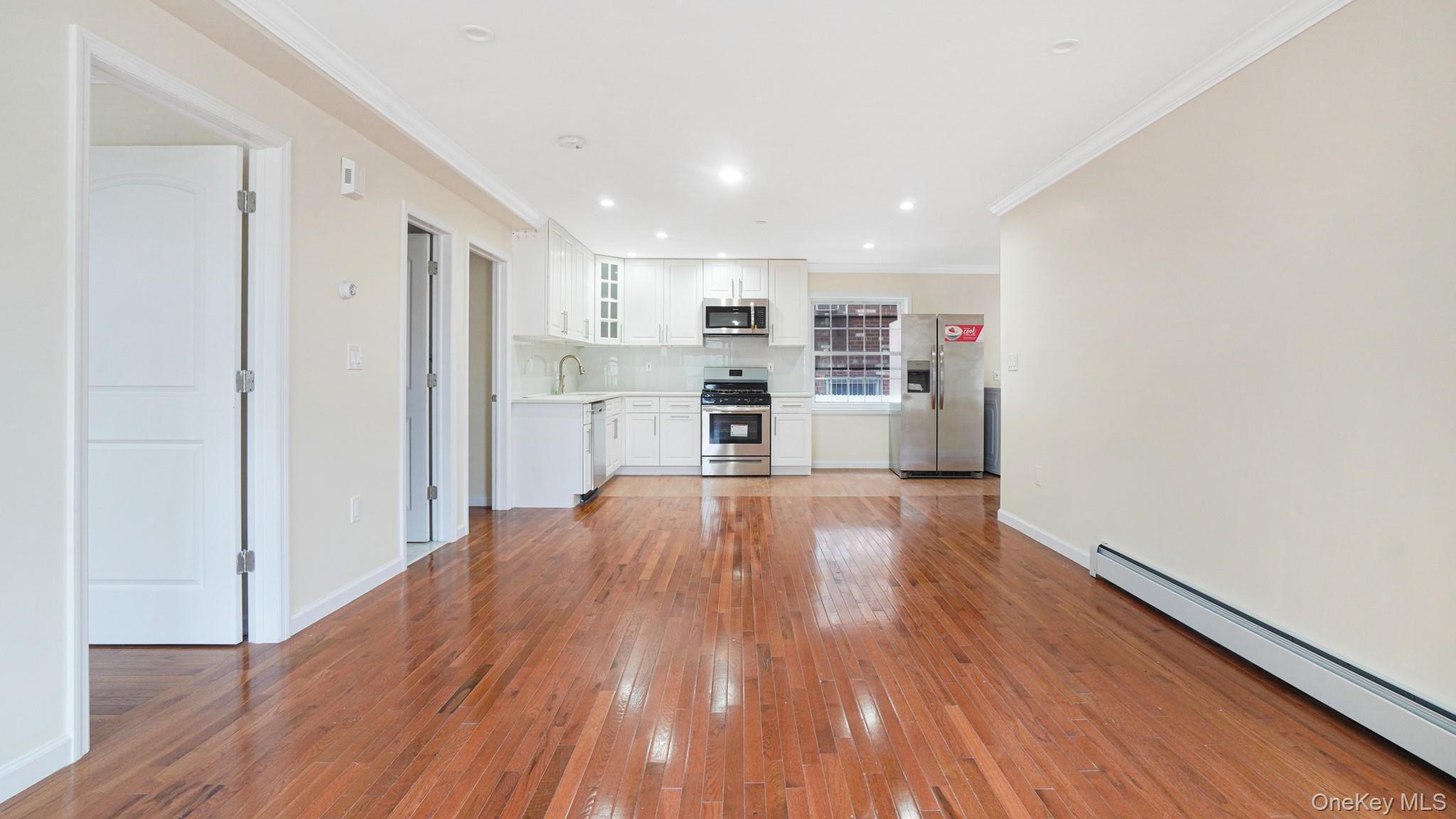 85-02 165th Street Queens, NY 11432 - Photo 28 of 36 Unfurnished living room featuring a baseboard radiator, crown molding, light wood-type flooring, and recessed lighting