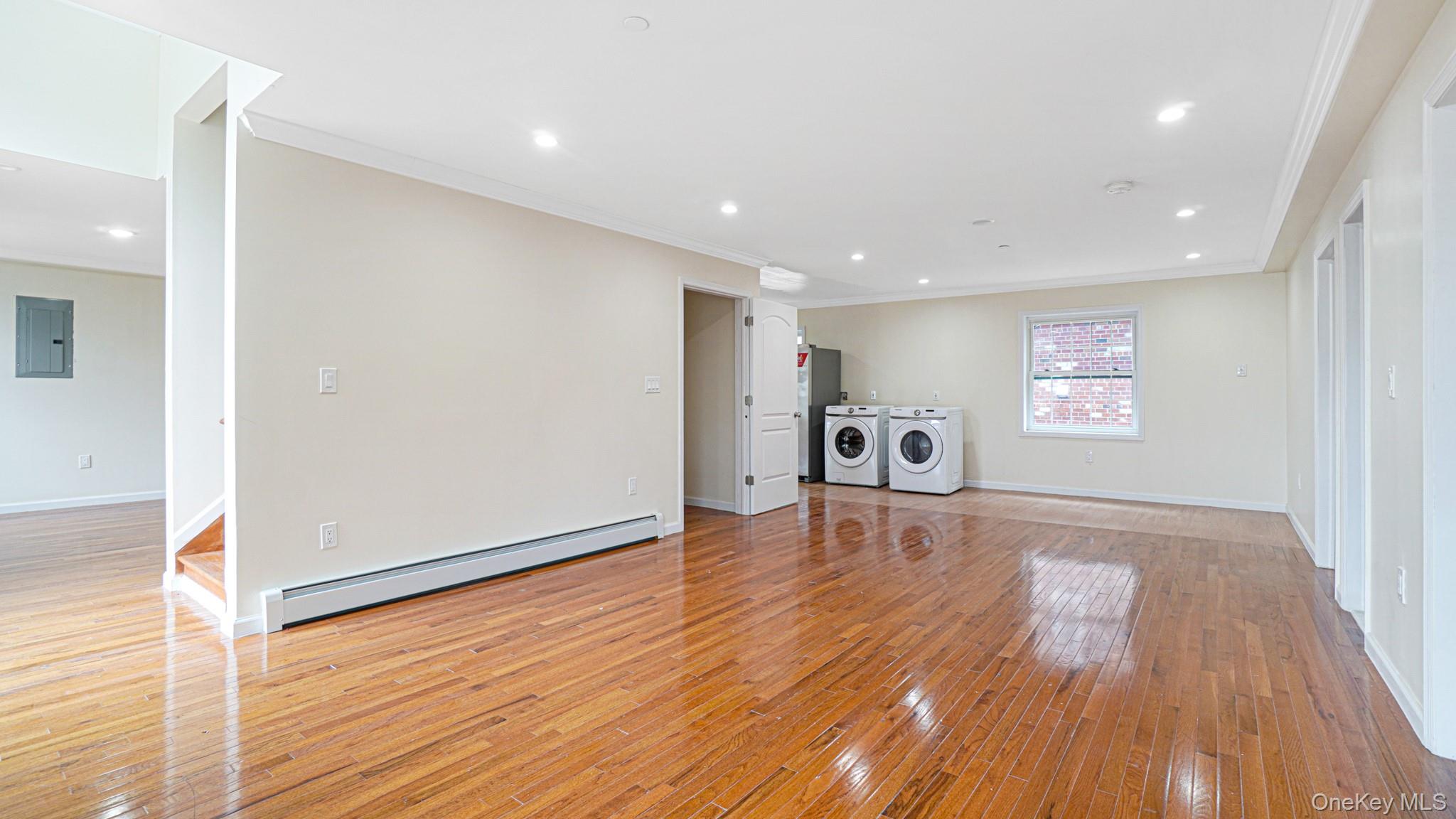 85-02 165th Street Queens, NY 11432 - Photo 29 of 36 Unfurnished living room with light wood-style floors, baseboard heating, recessed lighting, ornamental molding, and electric panel