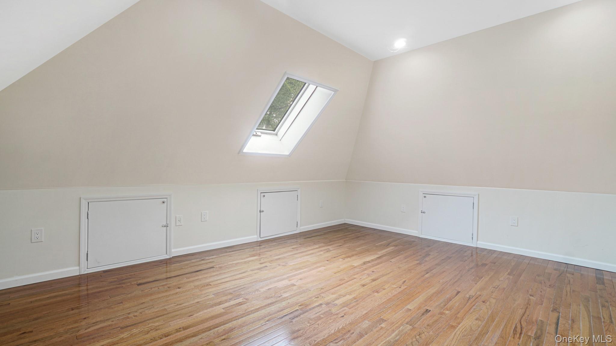 85-02 165th Street Queens, NY 11432 - Photo 33 of 36 Additional living space with light wood finished floors, vaulted ceiling, and a skylight