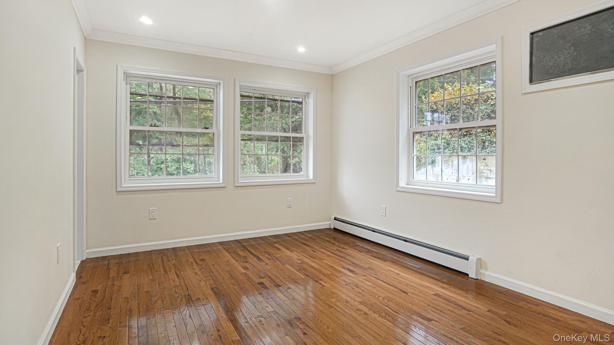 85-02 165th Street Queens, NY 11432 - Photo 8 of 36 Spare room featuring hardwood / wood-style floors, crown molding, a baseboard radiator, and recessed lighting
