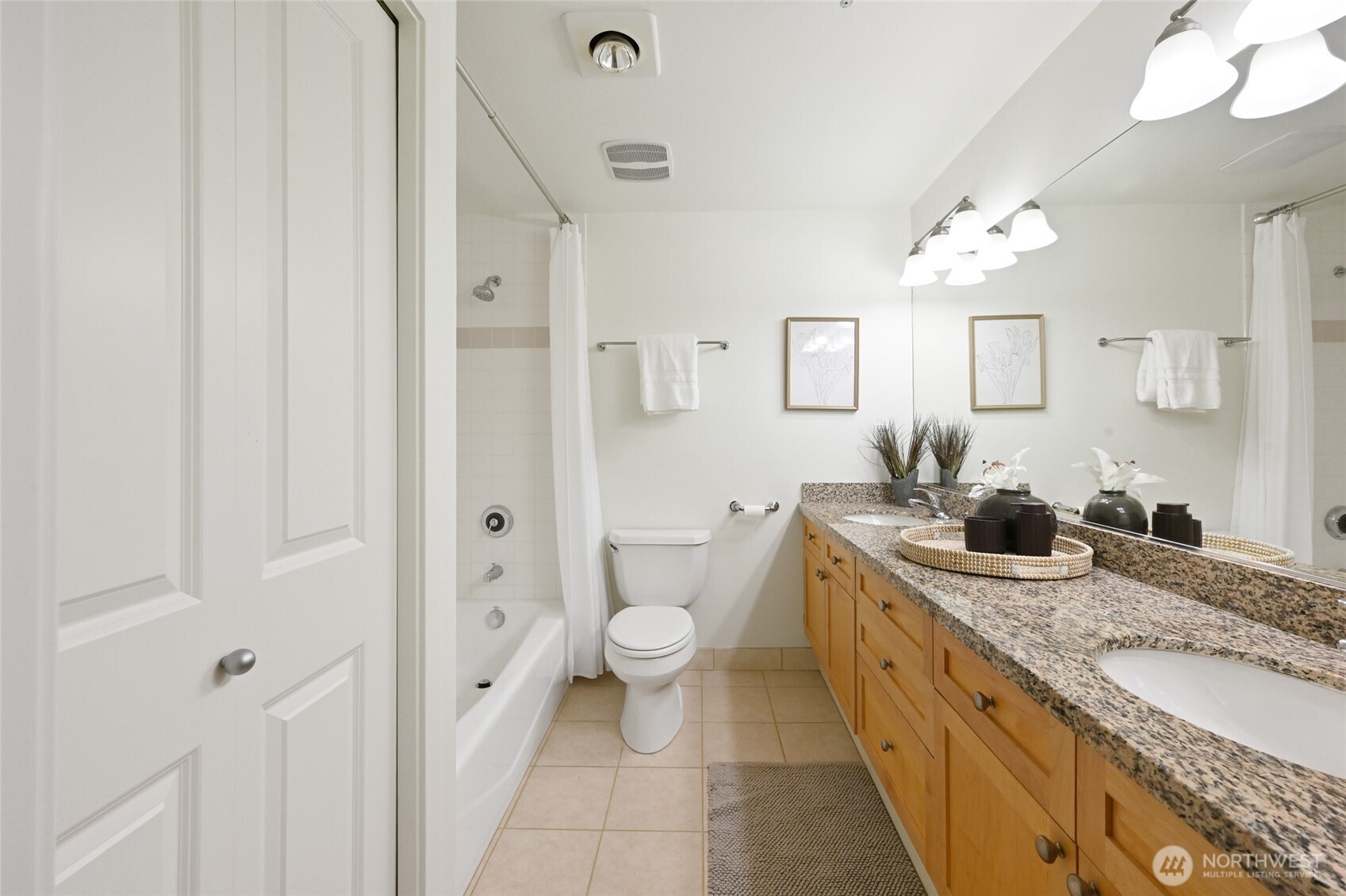 2331 42nd Avenue Southwest, Unit 209 Seattle, WA 98116 - Photo 11 of 21 a bathroom with a granite countertop sink a toilet a mirror and shower