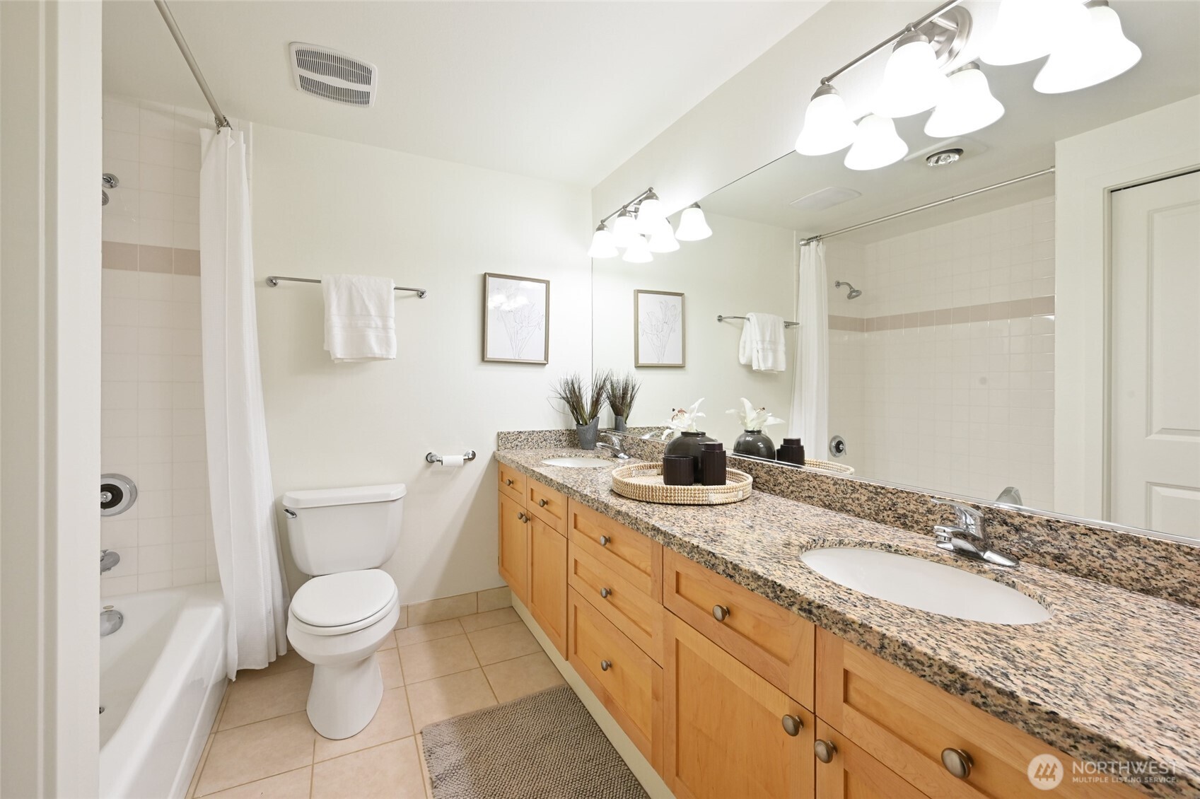2331 42nd Avenue Southwest, Unit 209 Seattle, WA 98116 - Photo 12 of 21 a spacious bathroom with a granite countertop double vanity sink a mirror and a toilet