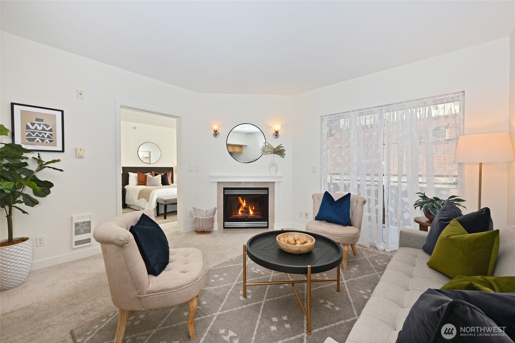 2331 42nd Avenue Southwest, Unit 209 Seattle, WA 98116 - Photo 3 of 21 a living room with furniture a table and a fireplace