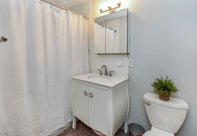 a bathroom with a sink toilet and shower