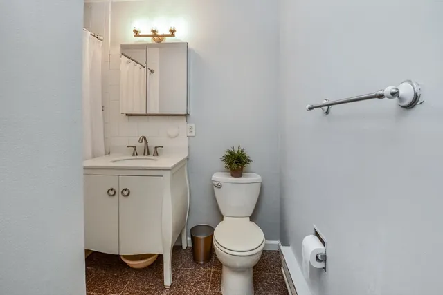 a bathroom with a toilet sink and mirror