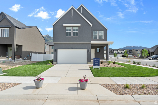 722 West 2840 South, Unit 8 Logan, UT 84321 - Photo 2 of 23 View of front facade with a residential view, stucco siding, an attached garage, and concrete driveway