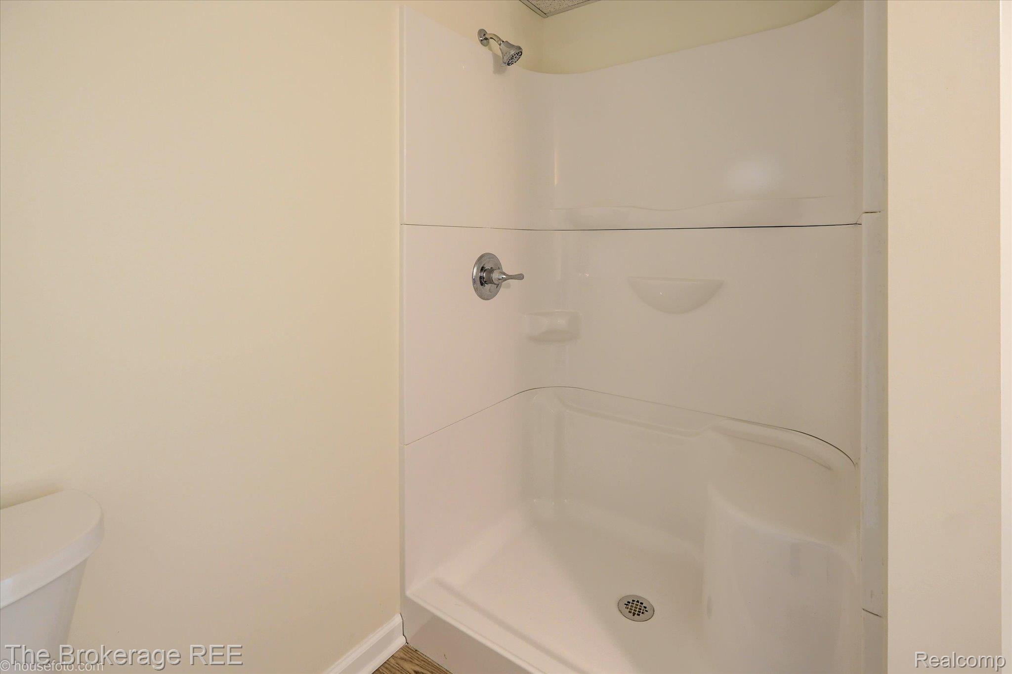1077 Hadley Road Lapeer, MI 48446 - Photo 45 of 61 White shower enclosure featuring a chrome shower head and faucet, integrated soap dishes, and a textured floor