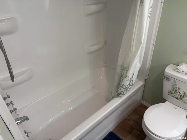 a white toilet sitting next to a bath tub