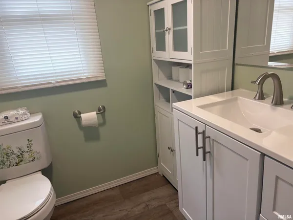 a bathroom with a sink toilet and a window