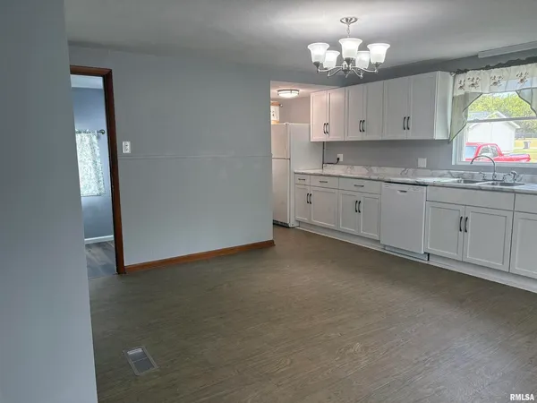 a kitchen with granite countertop white cabinets a sink dishwasher and a granite counter top
