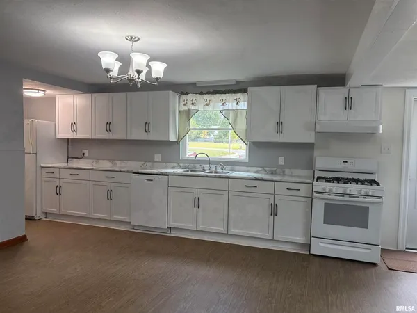 a kitchen with granite countertop white cabinets stainless steel appliances and window