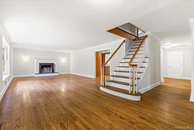 a view of a livingroom with wooden floor and staircase