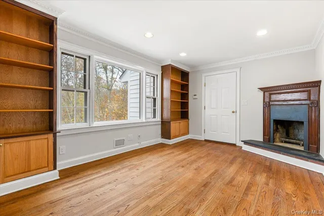 a view of an empty room with a window and fireplace