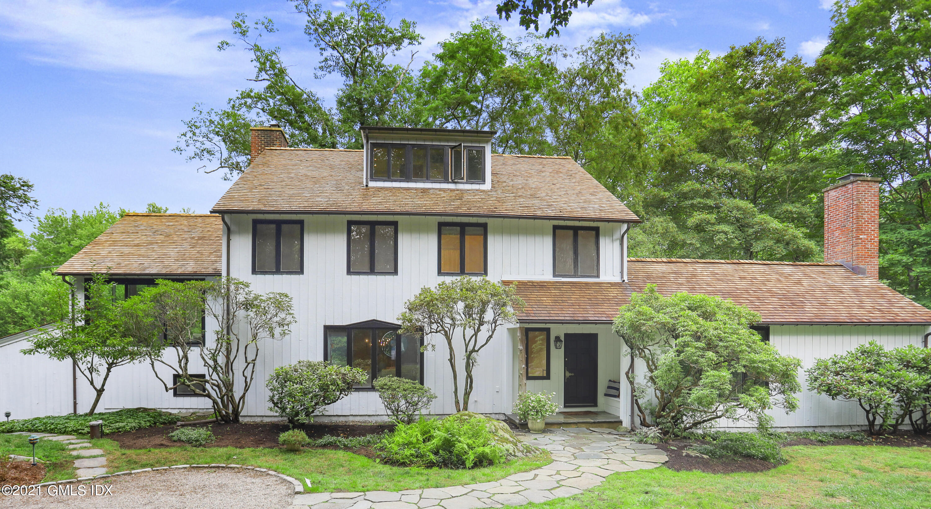 a front view of a house with a yard and potted plants