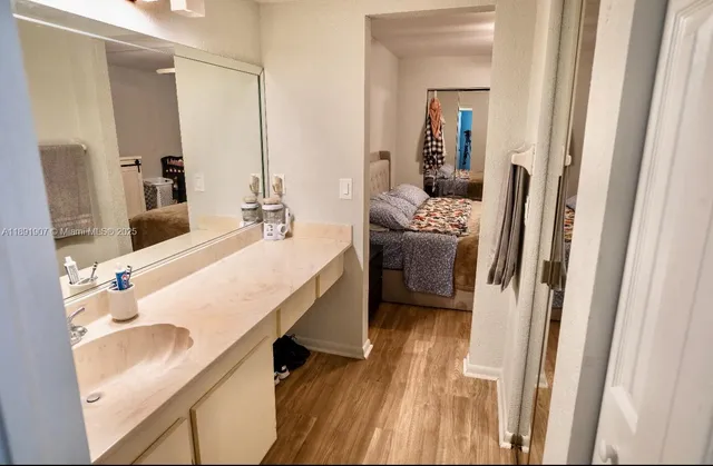 a en suite bathroom with a granite countertop sink and a mirror