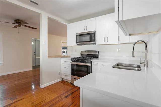 a kitchen with stainless steel appliances a stove a sink a refrigerator and cabinets