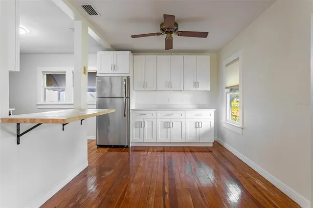 a kitchen with wooden floors and white cabinets