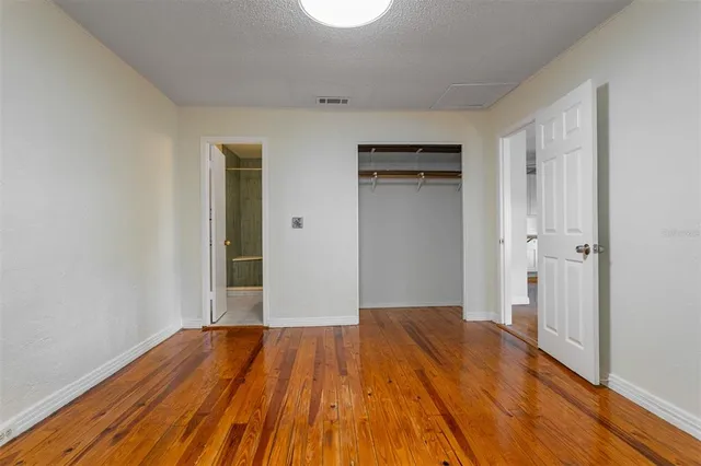 a view of a room with wooden floor and a bathroom