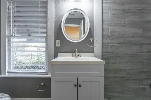 a bathroom with a sink a mirror and a window