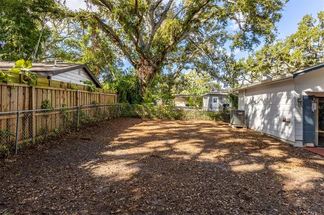 a view of backyard of house with green space