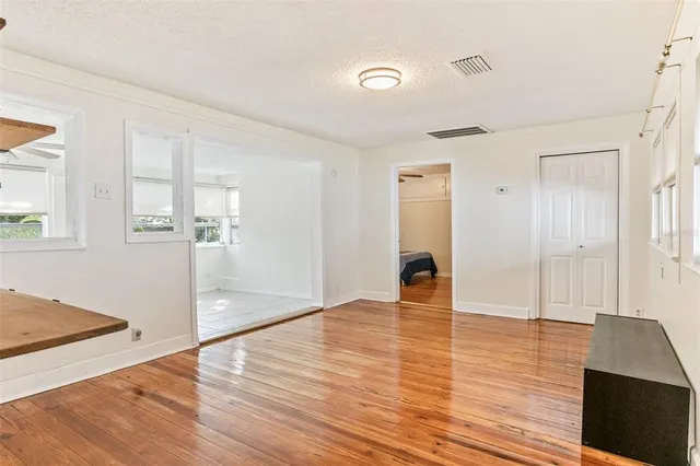 a view of empty room with wooden floor