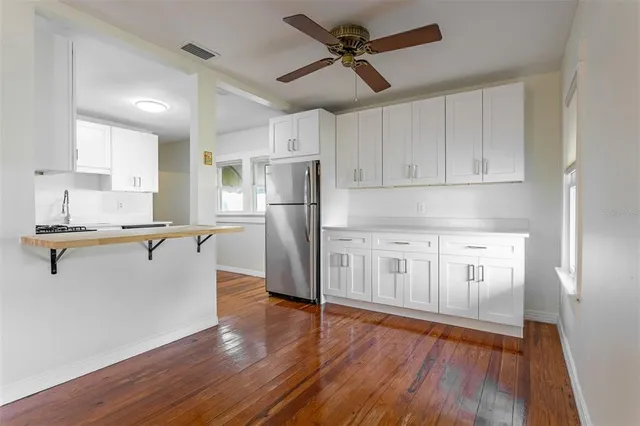 a kitchen with kitchen island white cabinets and stainless steel appliances