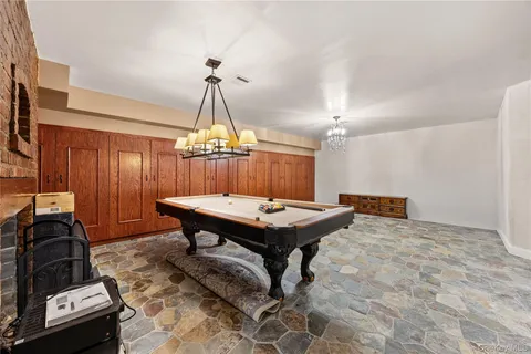 a room with furniture pool table and a chandelier