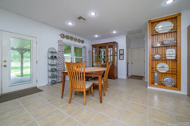 a dining area with stainless steel appliances a dining table and chairs