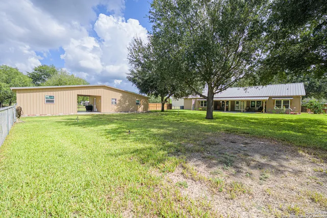 a view of a backyard with a garden and tree