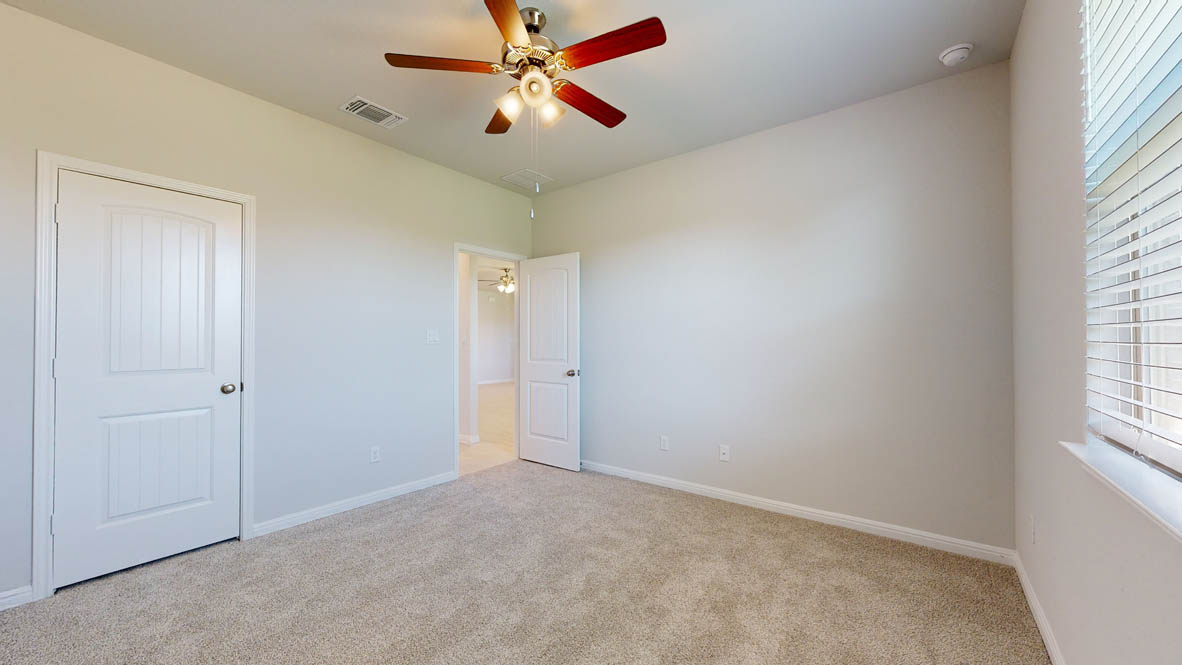 808 Gauge Road Thorndale, TX 76577 - Photo 22 of 31 A well-lit bedroom features plush carpeting and a modern ceiling fan, inviting relaxation.