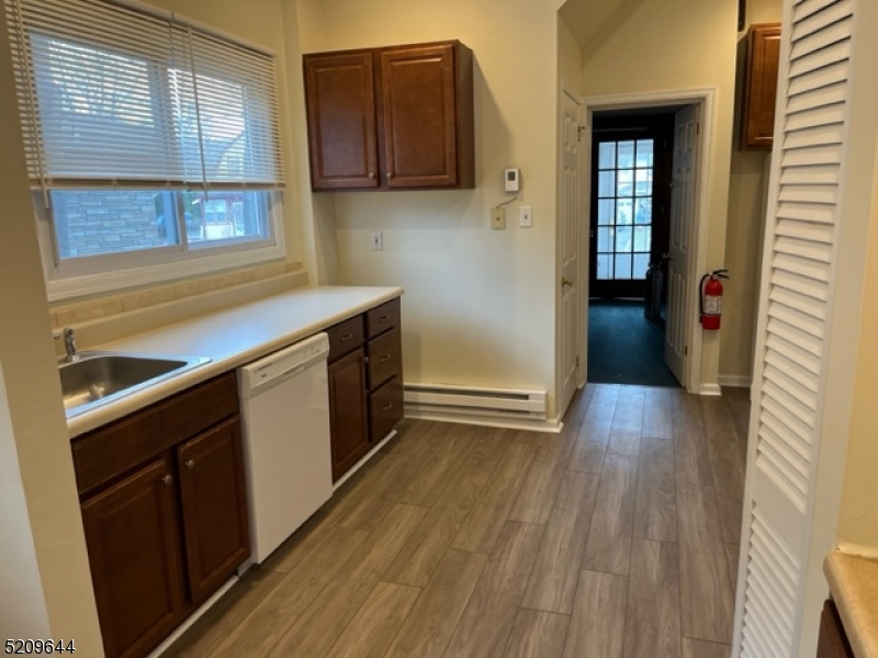123 Clark Street Dover, NJ 07801 - Photo 3 of 12 a kitchen with a wooden floor and a large window