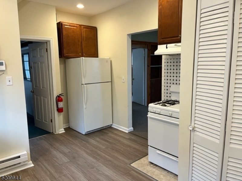 123 Clark Street Dover, NJ 07801 - Photo 4 of 12 a room with stainless steel appliances a refrigerator and a wooden floor