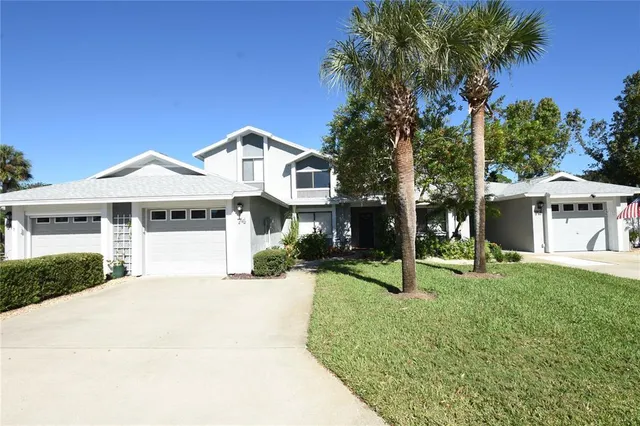 a front view of a house with a yard and palm trees