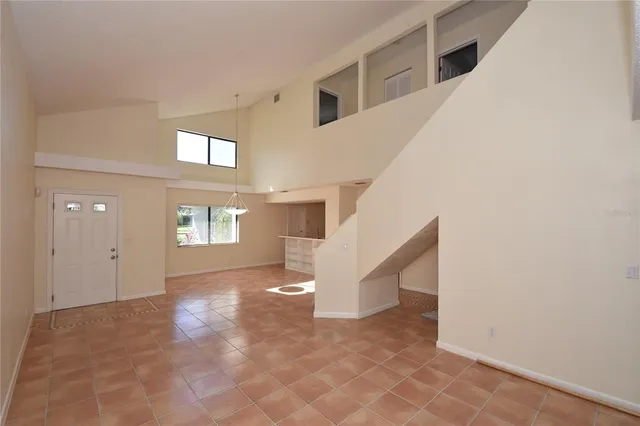 a view of an empty room with stairs and a window