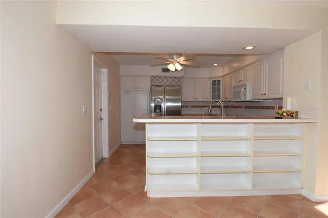 a view of kitchen cabinets and chandelier
