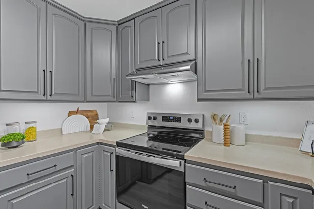 a kitchen with stainless steel appliances granite countertop a sink a stove and cabinets