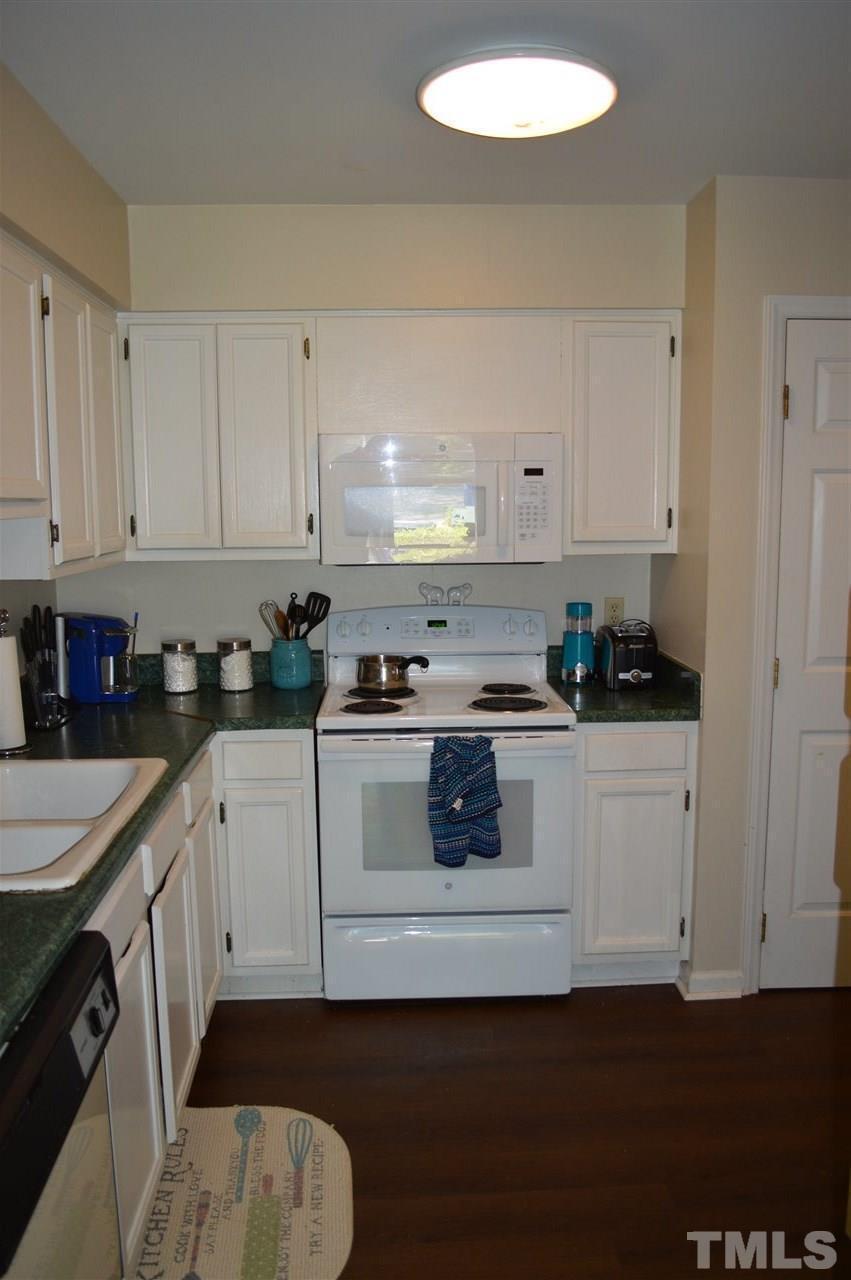 1945 Trexler Court Raleigh, NC 27606 - Photo 5 of 13 a kitchen with granite countertop white cabinets and white appliances