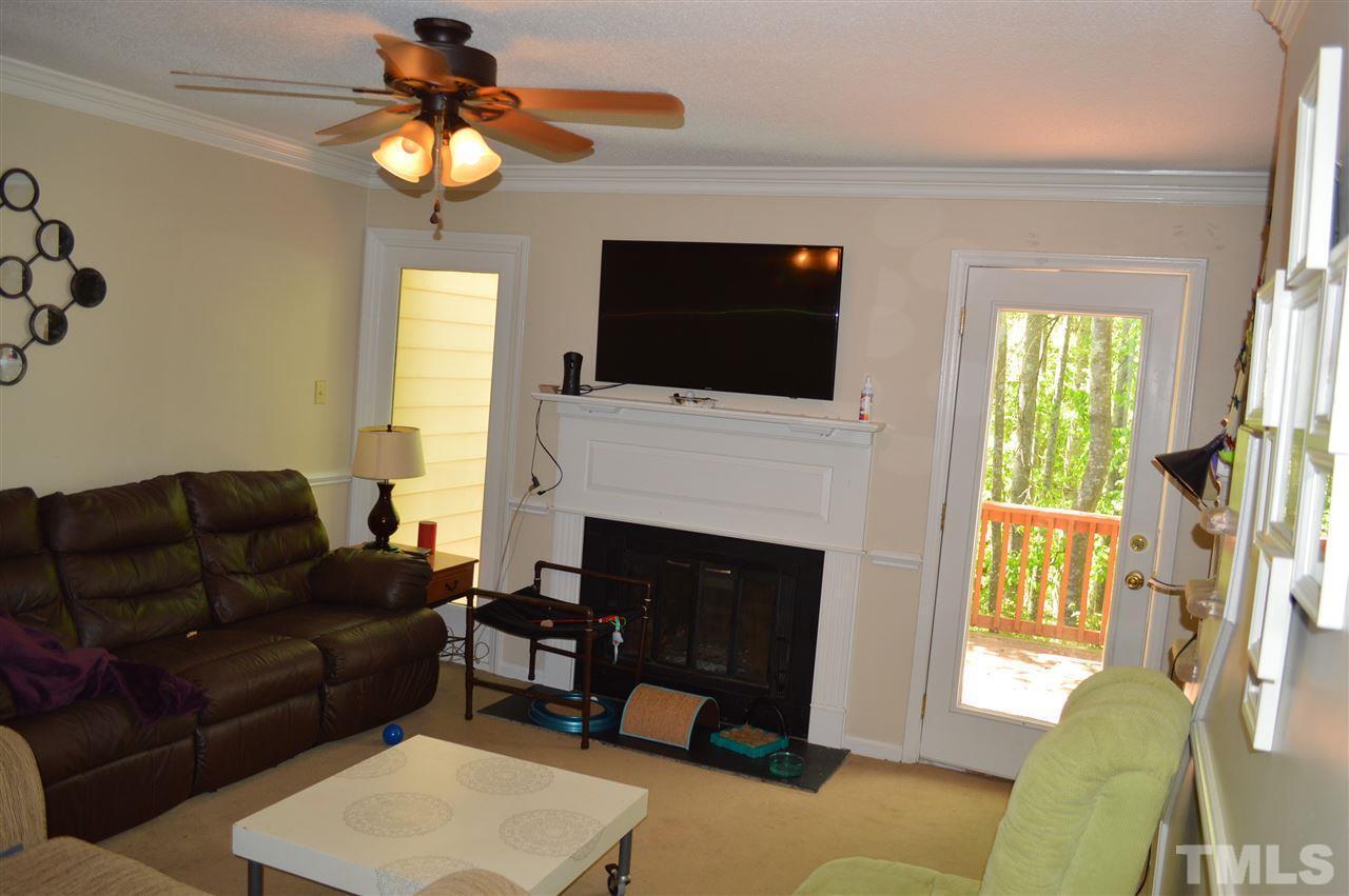 1945 Trexler Court Raleigh, NC 27606 - Photo 8 of 13 a living room with furniture a fireplace and a flat screen tv