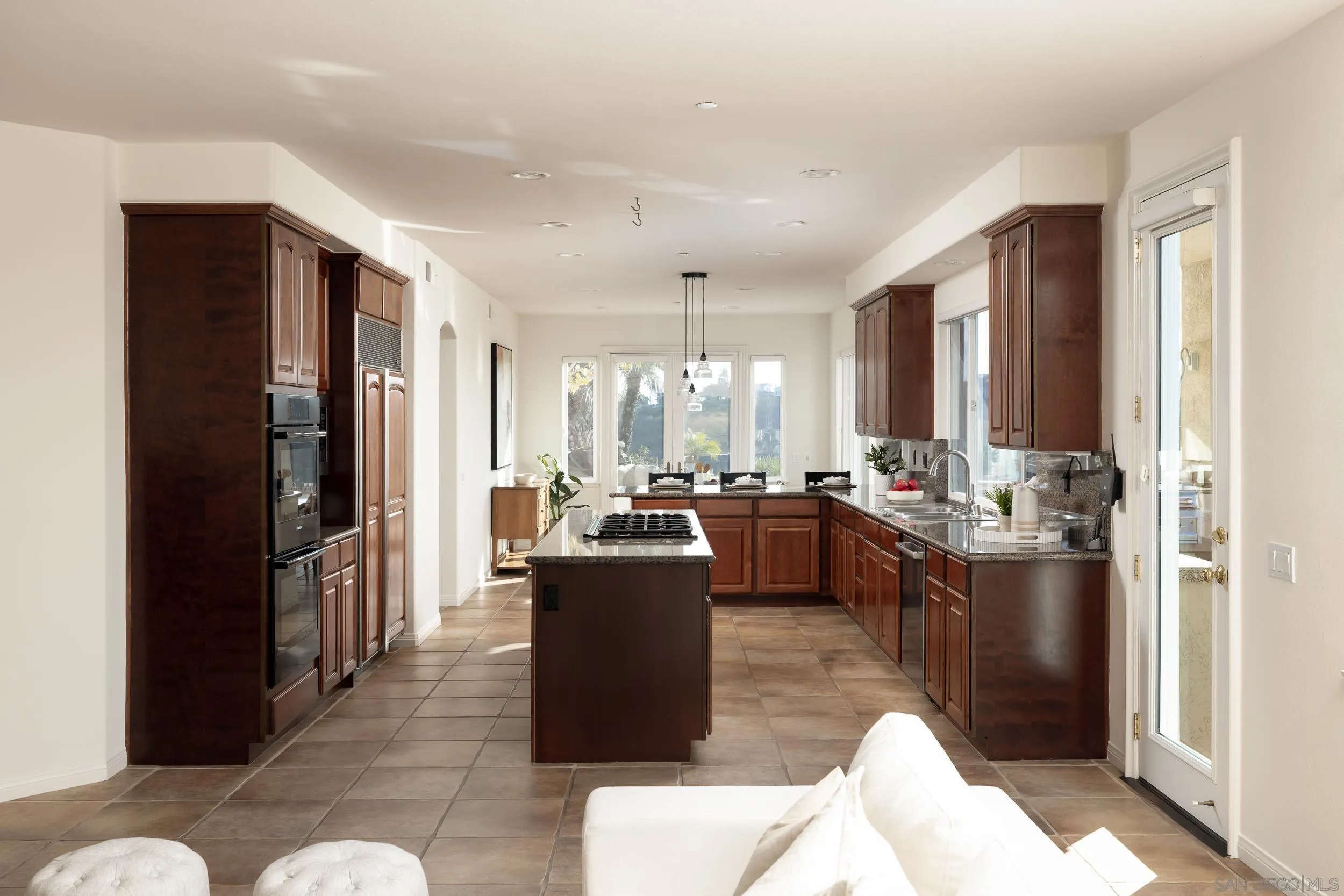 1786 Swallowtail Road Encinitas, CA 92024 - Photo 12 of 46 a kitchen with stainless steel appliances kitchen island granite countertop a refrigerator a sink a stove and a refrigerator