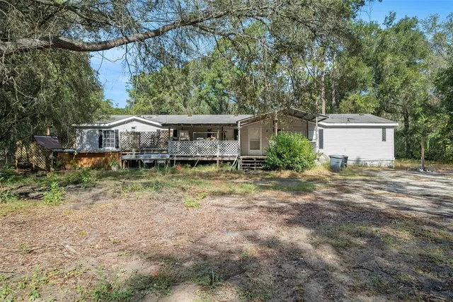 a view of house with yard and sitting area