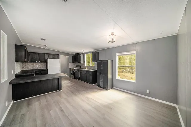a large kitchen with stainless steel appliances granite countertop a stove cabinets and wooden floor