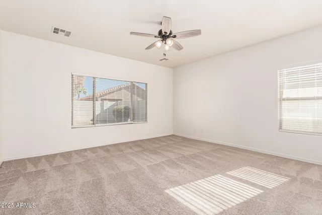 an empty room with a ceiling fan and a window