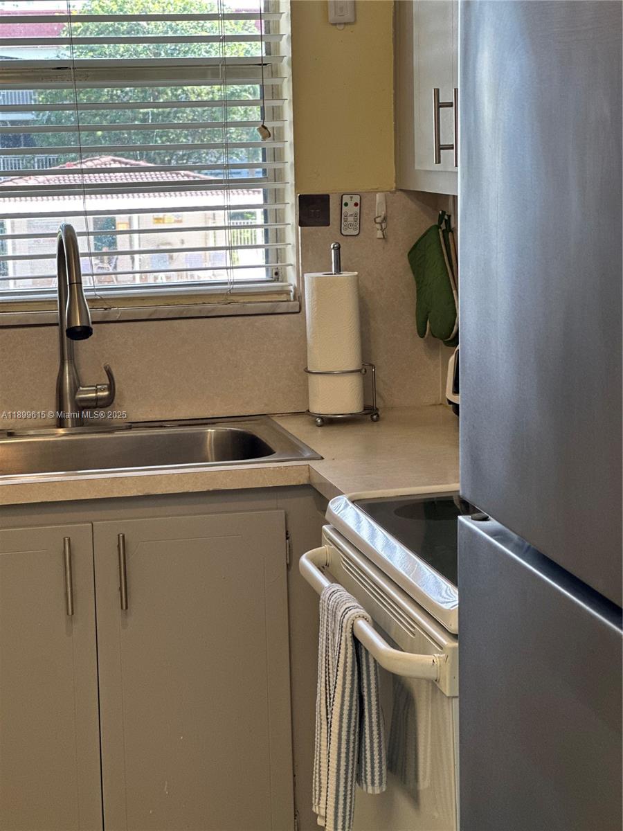 581 Blue Heron Drive, Unit 208B Hallandale Beach, FL 33009 - Photo 11 of 23 a kitchen with a sink and a window