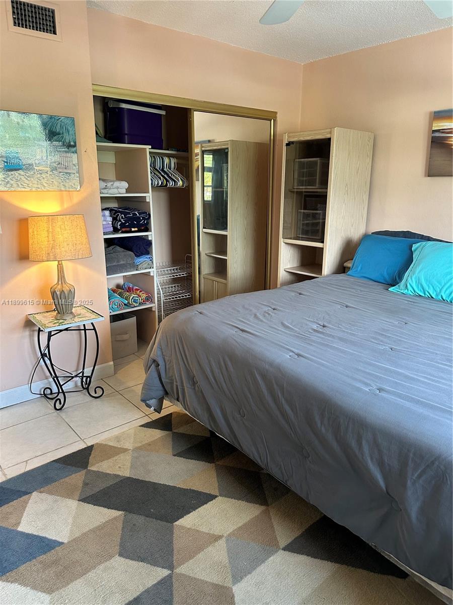 581 Blue Heron Drive, Unit 208B Hallandale Beach, FL 33009 - Photo 13 of 23 a bedroom with a bed and cabinets